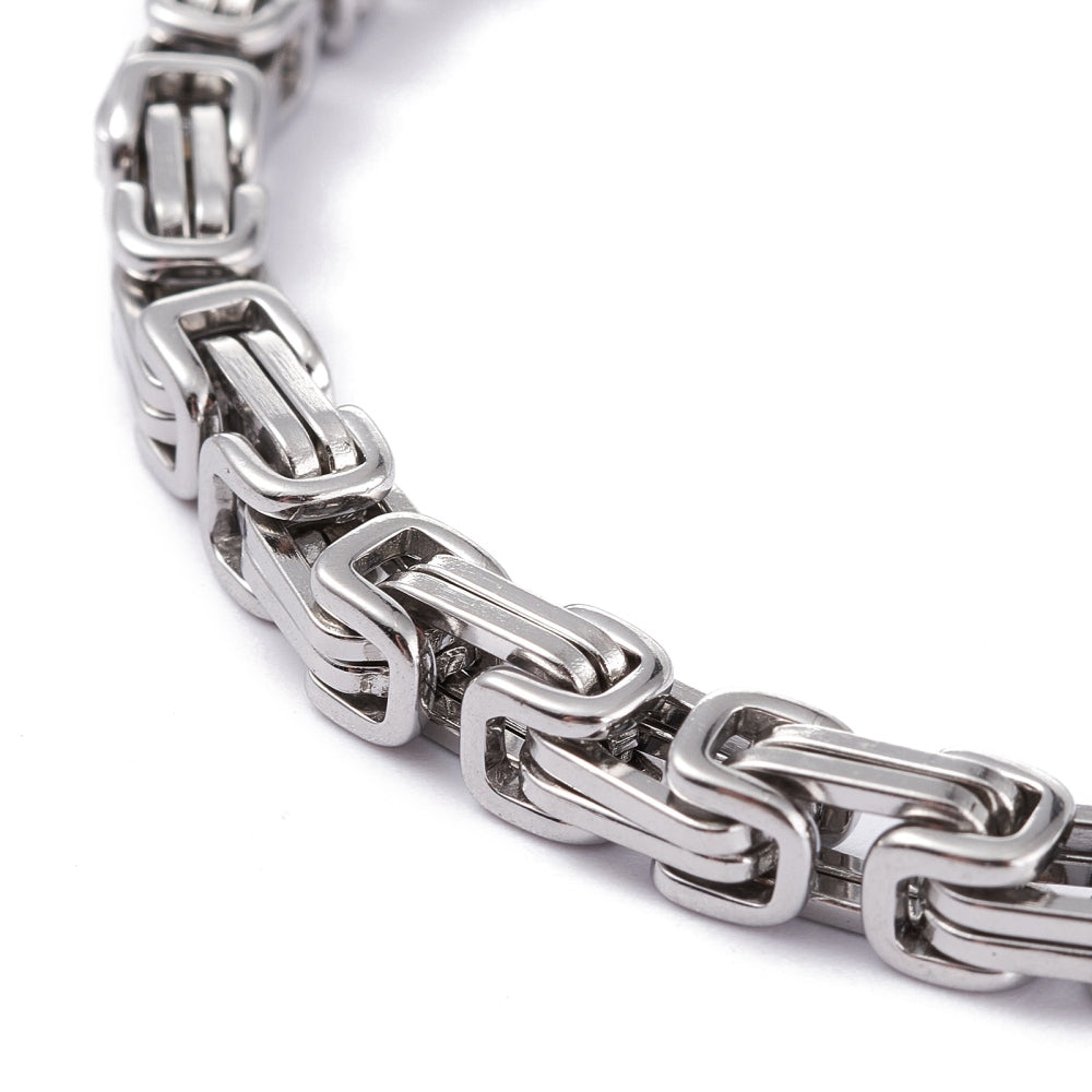 zoomed in section of silver Byzantine chain bracelet on white background. 