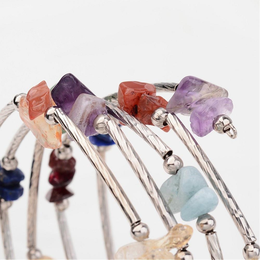 zoomed in sections of wrap bracelets made from piece of memory wire interspersed with tube beads along with clear quartz, jasper, citrine, carnelian, aventurine, lapis, and amethyst beads over white background. 