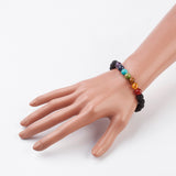 black lava rock stretch chakra bracelet featuring seven chakra round stone beads displayed on a mannequin hand over white background. 