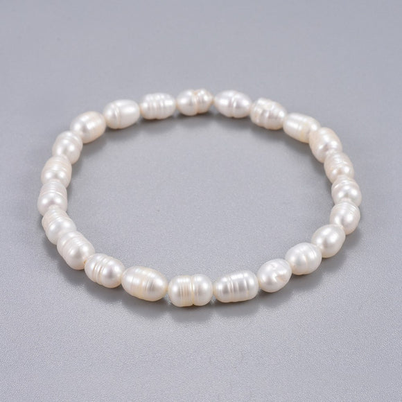 freshwater white potato pearl stretchy bracelet over grey background. 