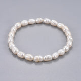 freshwater white potato pearl stretchy bracelet over grey background. 