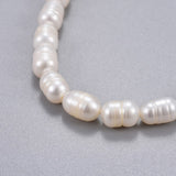 zoomed in section of freshwater white potato pearl stretchy bracelet over grey background. 