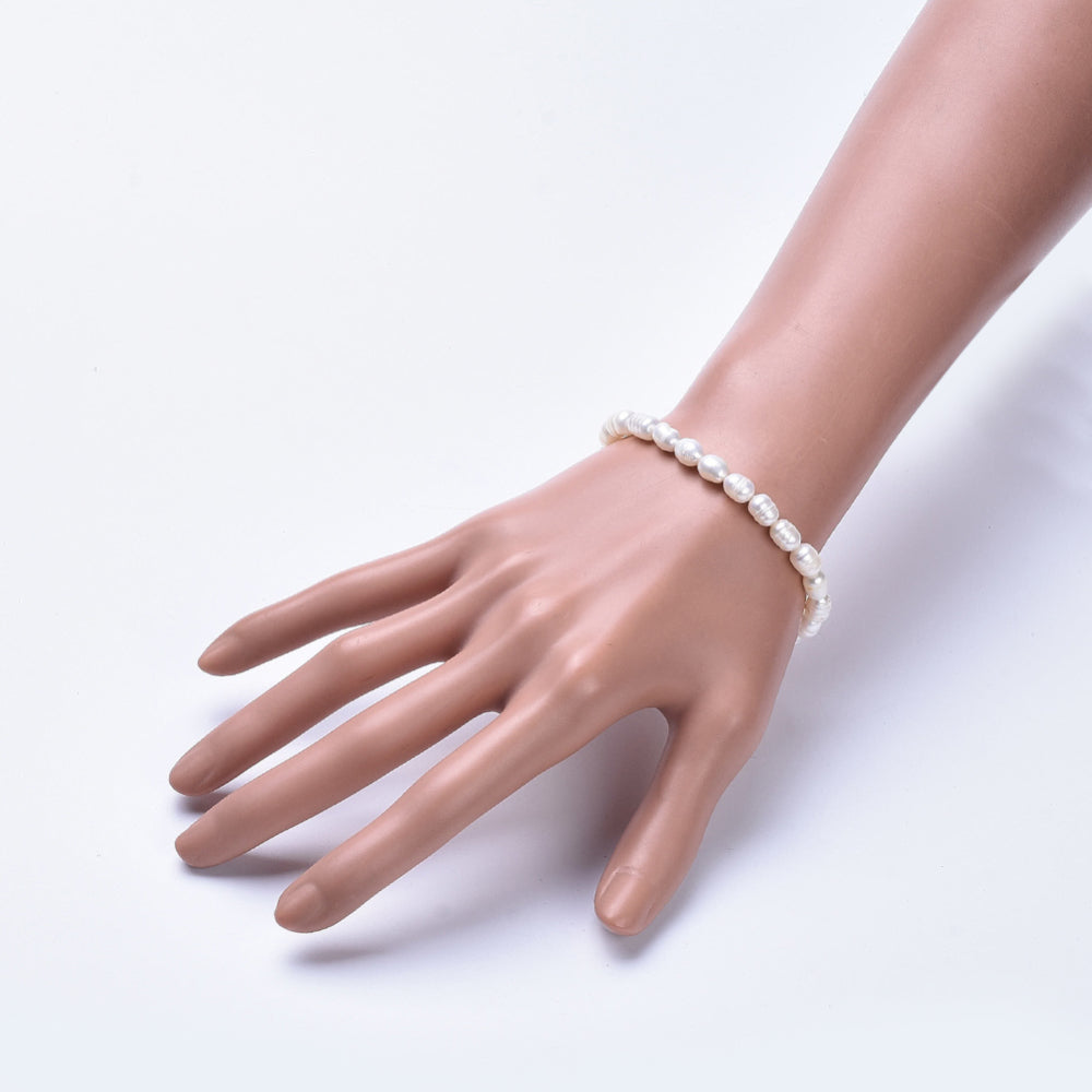 freshwater white potato pearl stretchy bracelet displayed on mannequin hand over white background. 