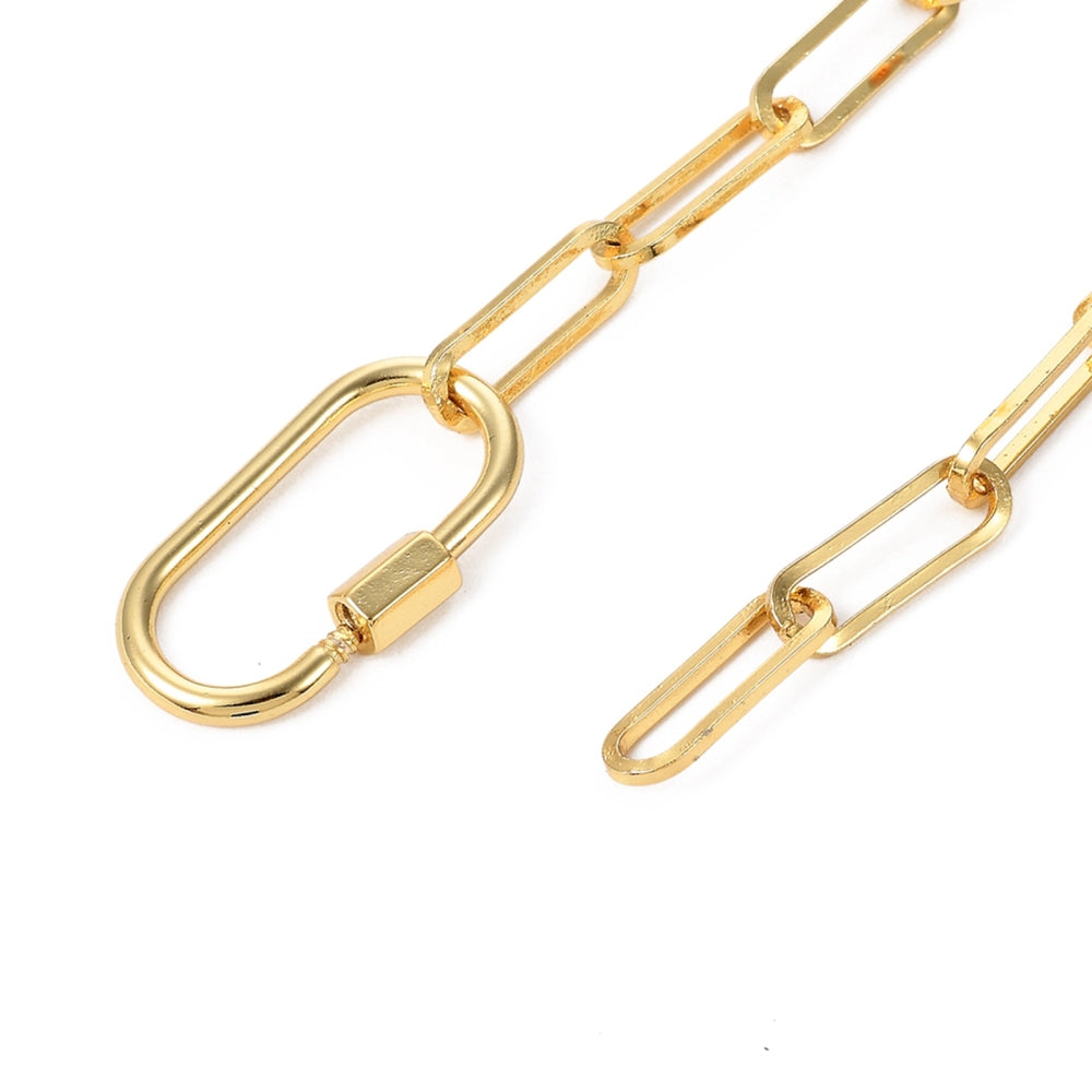 zoomed in section of golden paperclip chain bracelet with carabiner clasp depicted unclasped over white background. 