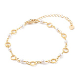 golden chain bracelet alternating ring and white faux pearl links with lobster claw clasp and extender chain over white background.