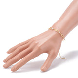 golden chain bracelet alternating ring and white faux pearl links and extender chain displayed on mannequin wrist over white background.