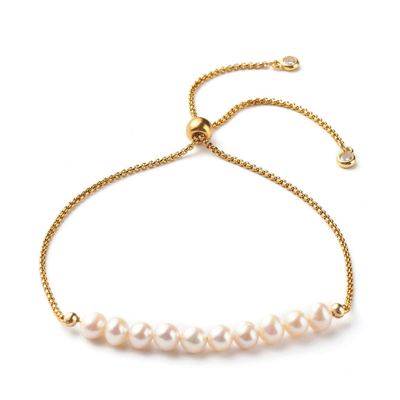 adjustable golden box chain and pearl bracelet with slider bead and bezel set clear stone stopper beads over white background. 