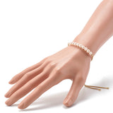 adjustable golden box chain and pearl bracelet with bezel set clear stone stopper beads displayed on mannequin wrist over white background. 