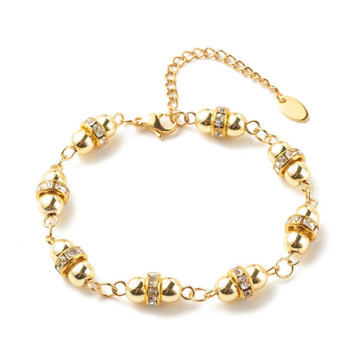 golden hematite and rhinestone link bracelet with lobster claw clasp and extender chain over white surface. 