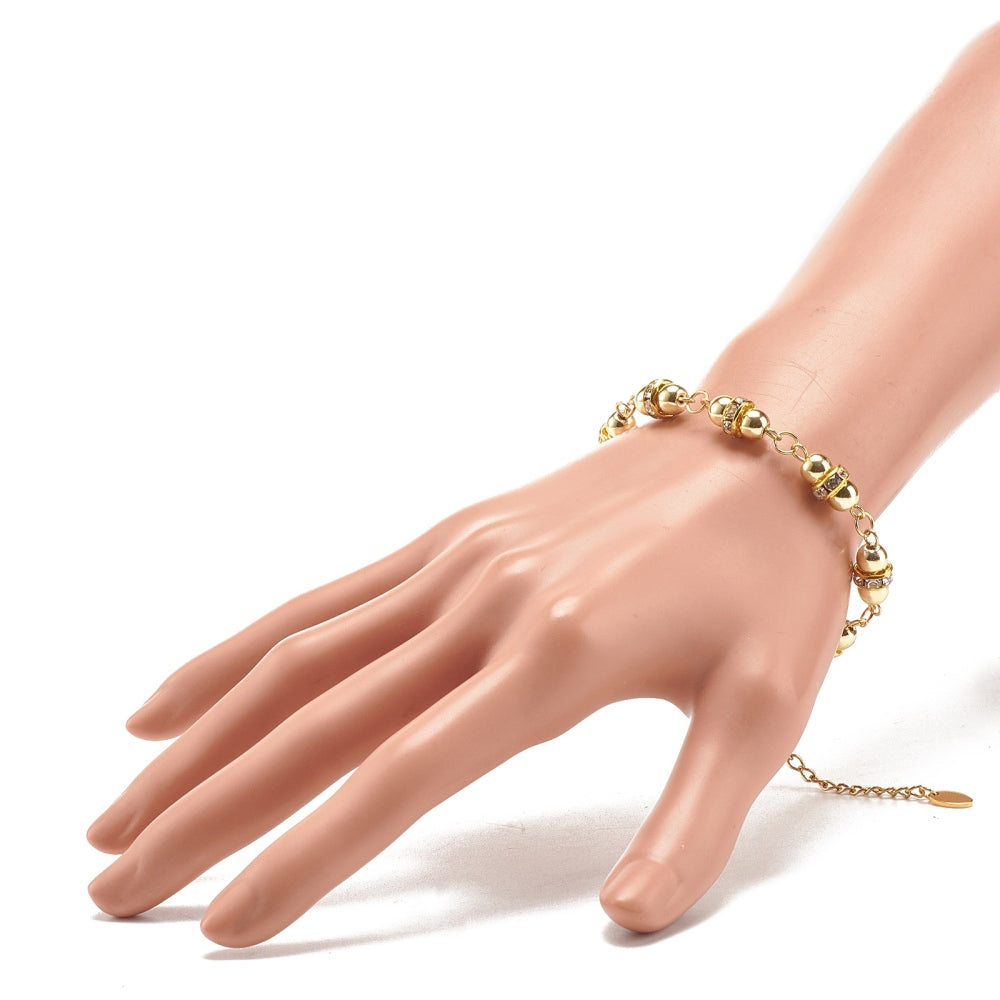 golden hematite and rhinestone link bracelet with lobster claw clasp and extender chain displayed on a mannequin wrist over white surface. 