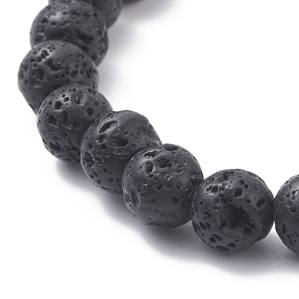 zoomed in section of stretch bracelet with round, black lava rock beads on a white background. 