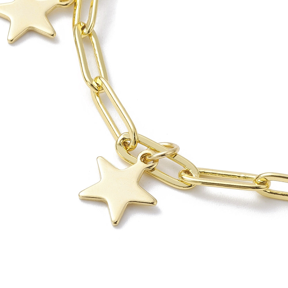 zoomed in section of golden paperclip chain bracelet with star charms over white surface. 