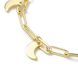 zoomed in section of golden paperclip chain with crescent moon charms over white background. 