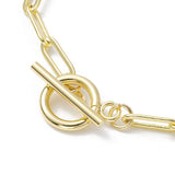 zoomed in golden toggle clasp on paperclip chain over white background. 