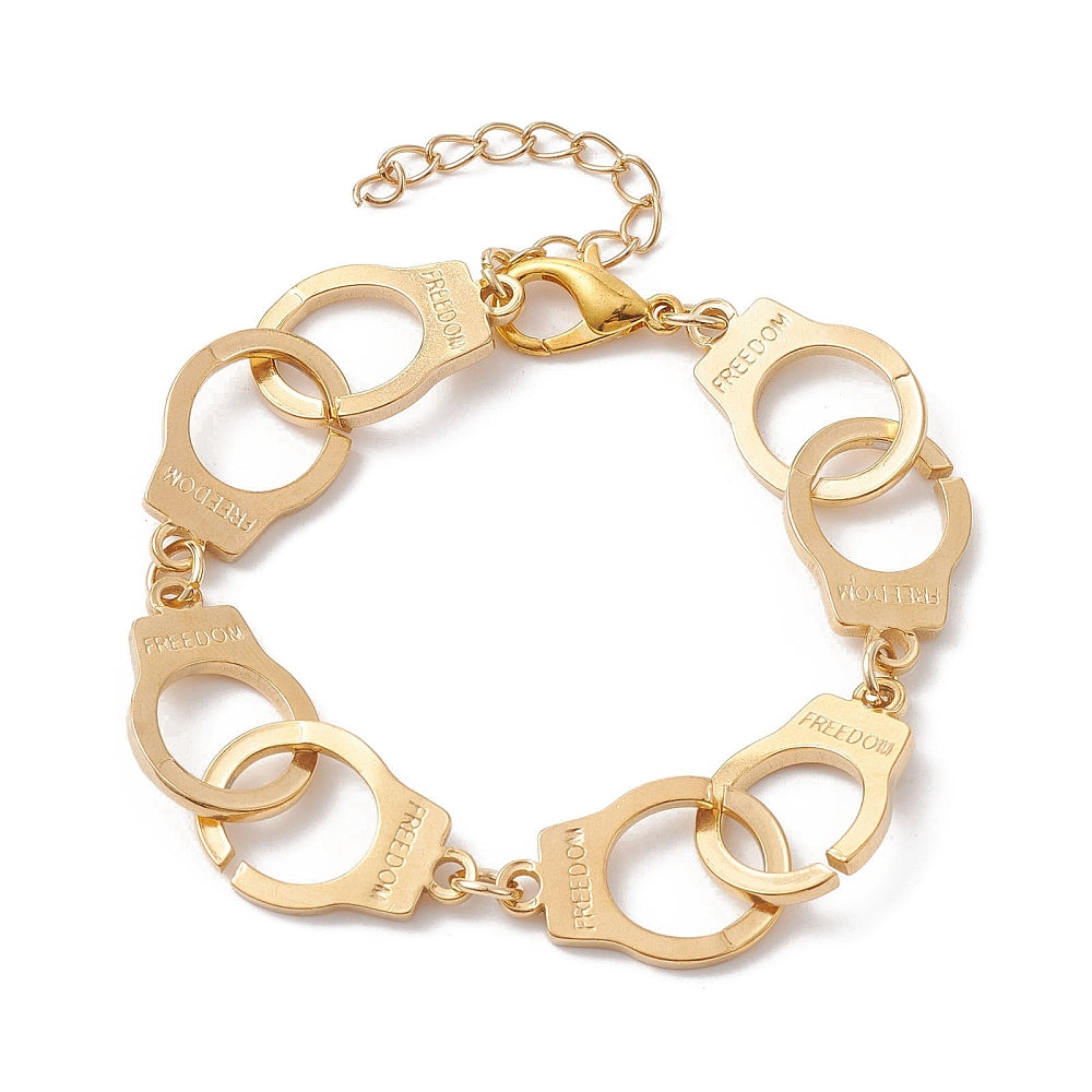golden handcuff link bracelet with the word "freedom" engraved on each cuff and a lobster claw clasp and extender chain over white surface. 