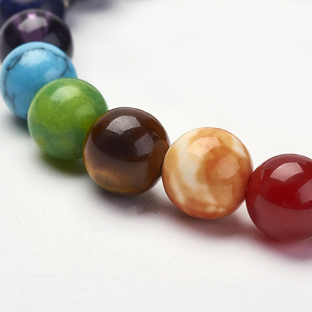 zoomed in charka round stone bead section of stretch bracelet over white background. 