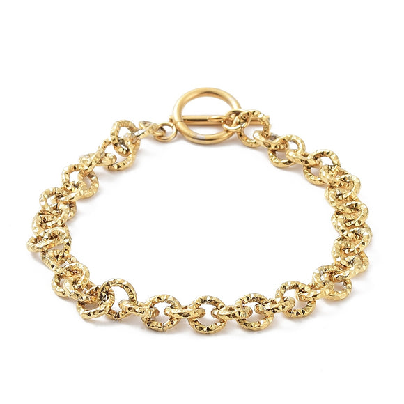 golden textured rolo link bracelet with large, smooth toggle clasp on white surface. 