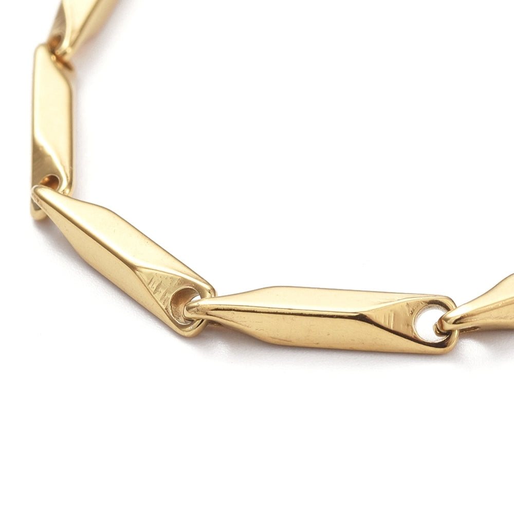 zoomed in section of golden bar link chain over white background. 