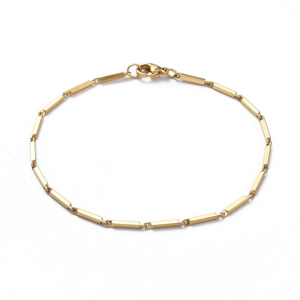 golden bar link bracelet with lobster claw clasp over white background. 