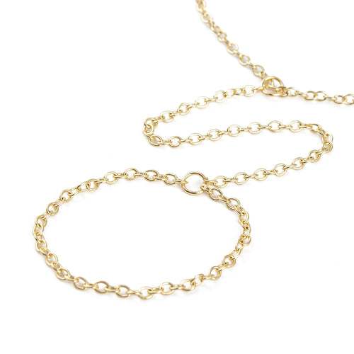 zoomed in section of golden hand chain bracelet with lobster claw clasp and extender chain over white background. 