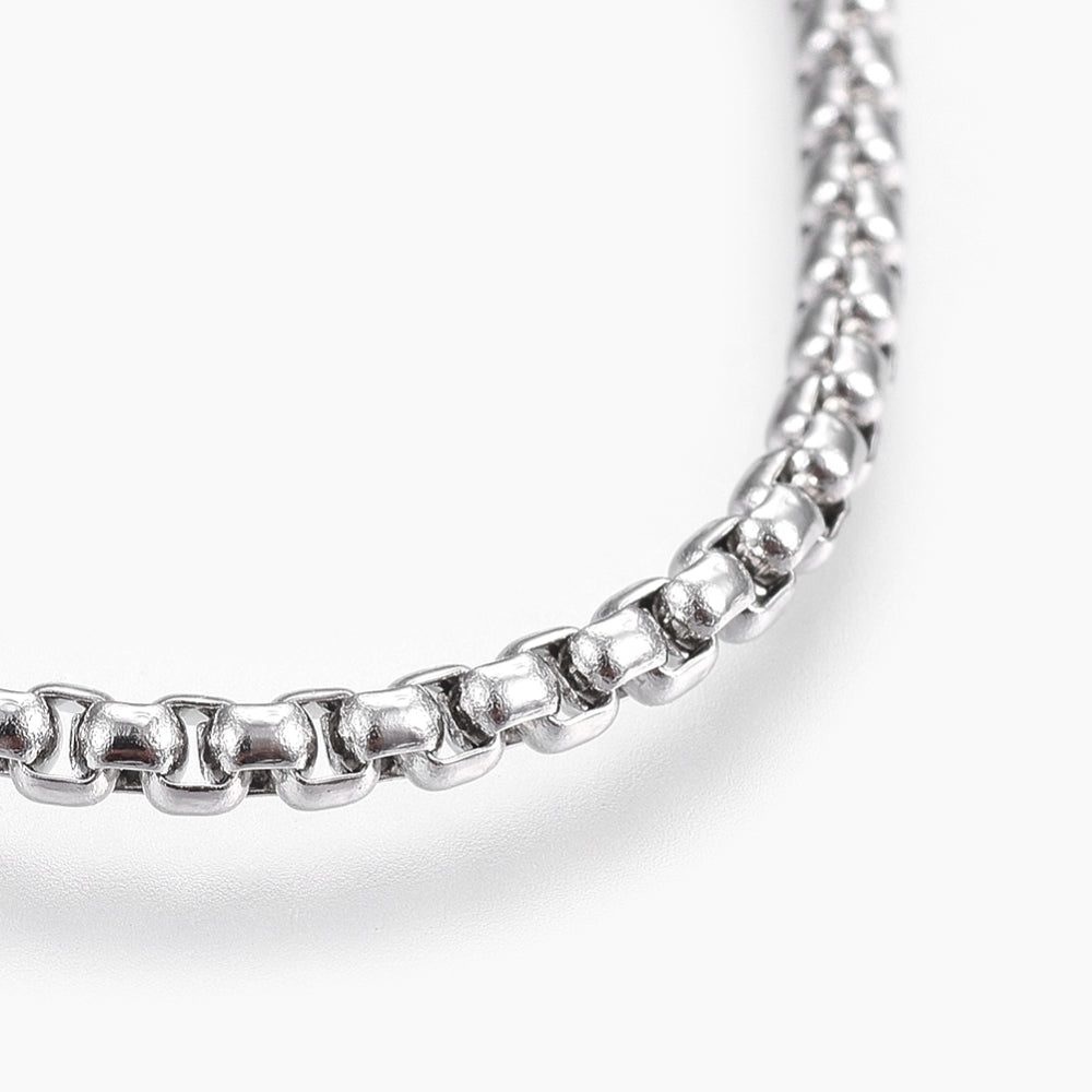 zoomed in section of silver tone box chain over white background. 