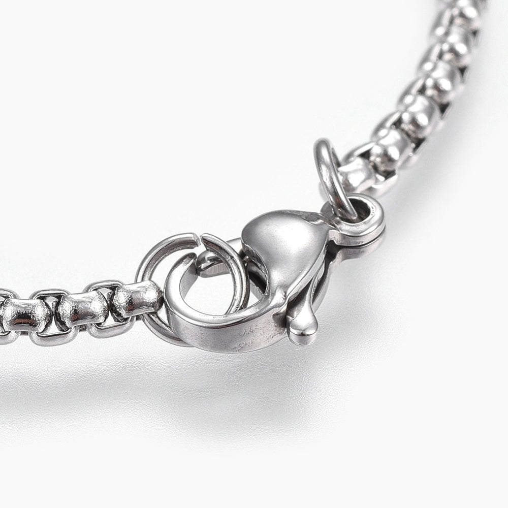 zoomed in section of silver tone lobster claw clasp on box chain over white background. 