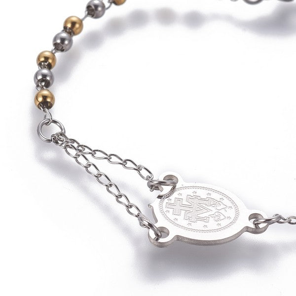 zoomed in back section of silver tone rosary bracelet with Virgin Mary connector piece a ball link chain over white background. 
