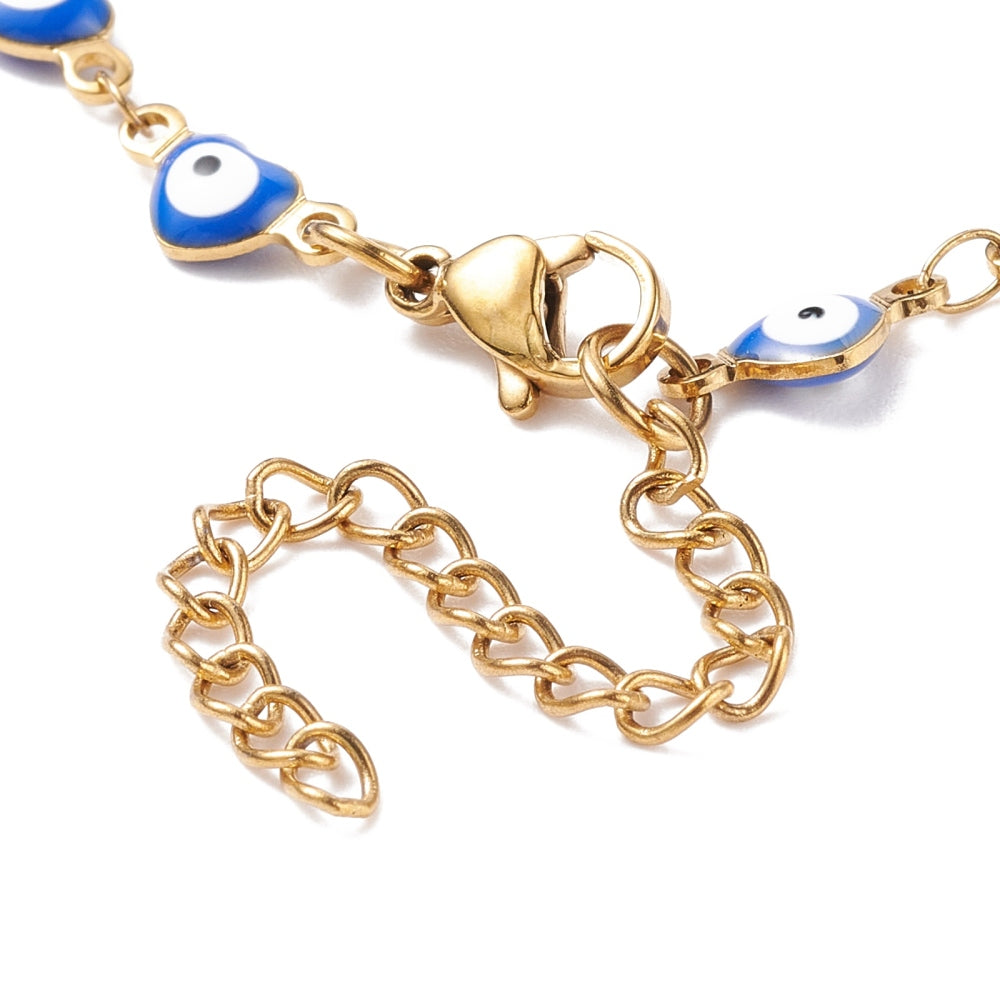 zoomed in section of golden and blue enamel heart shaped evil eye bracelet with lobster claw clasp and extender chain over white background.