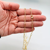 golden medium round oval paperclip chain necklace with lobster claw clasp on a hand on white background. 