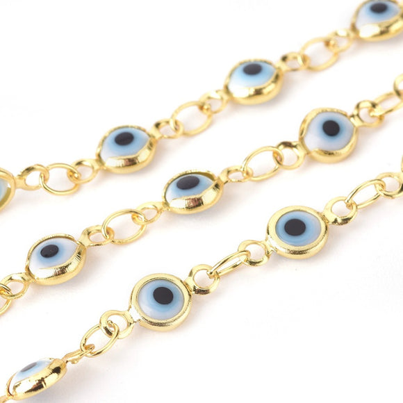 zoomed in sections of golden white and pale blue Evil Eye link chain necklace  over white background. 