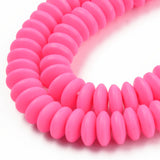 zoomed in sections of pink polymer clay saucer bead strands over white background. 