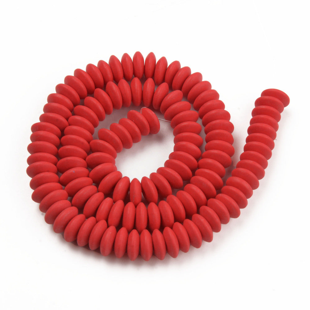 red polymer clay saucer bead strand in a swirl design over white background. 