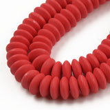 zoomed in sections of red polymer clay saucer bead strands over white background. 