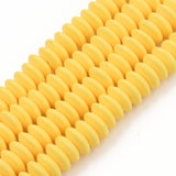 four yellow polymer clay saucer bead strands over white background. 