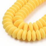 zoomed in sections of yellow polymer clay saucer bead strands over white background. 