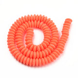 orange polymer clay saucer bead strand in a swirl design over white background. 