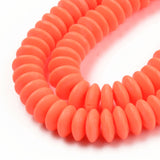 zoomed in sections of orange polymer clay saucer bead strands over white background. 