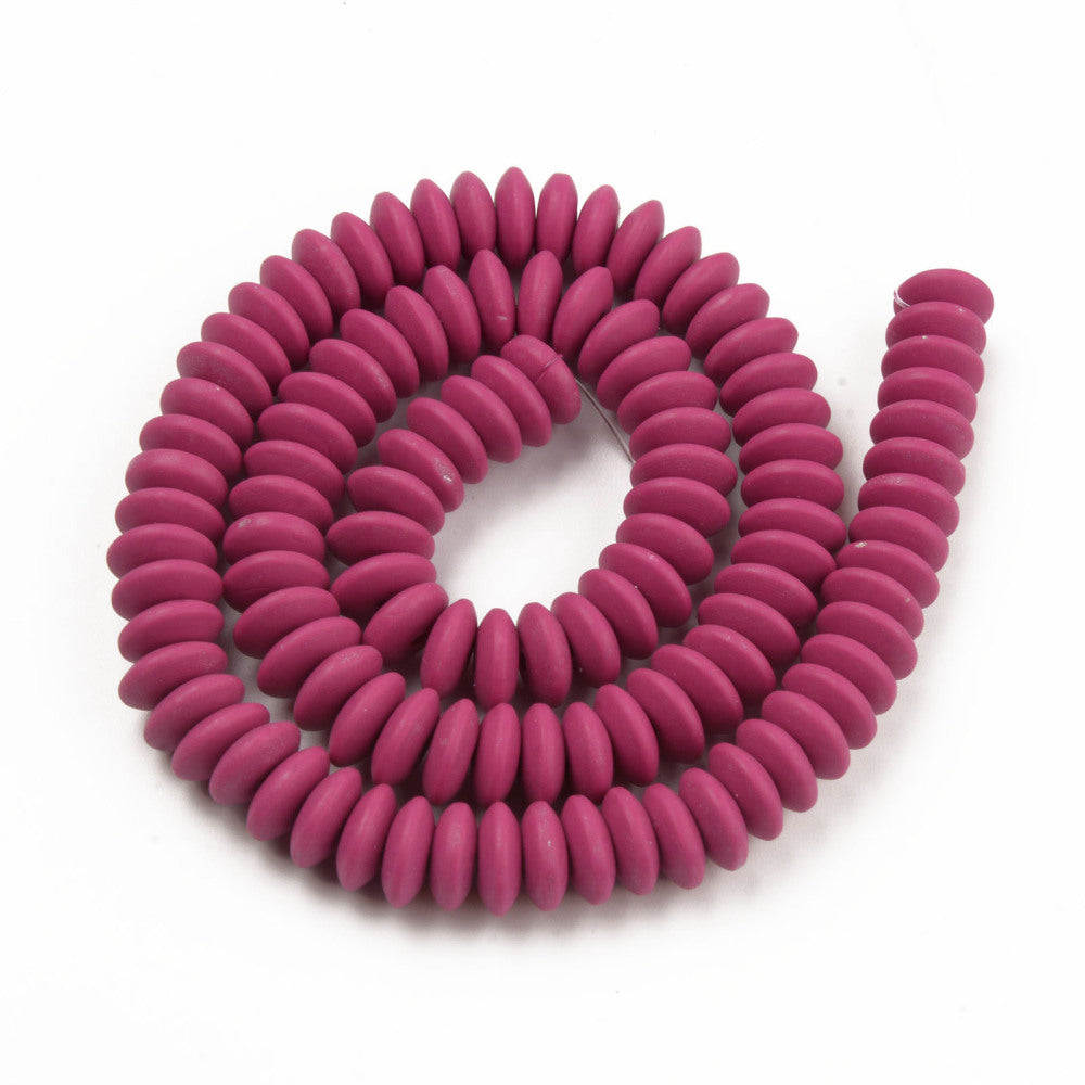 maroon polymer clay saucer bead strand in a swirl design over white background. 