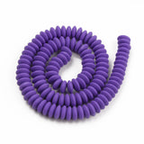 purple polymer clay saucer bead strand in a swirl design over white background. 