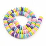 pastel multicolor polymer clay saucer bead strand in a swirl design over white background. 