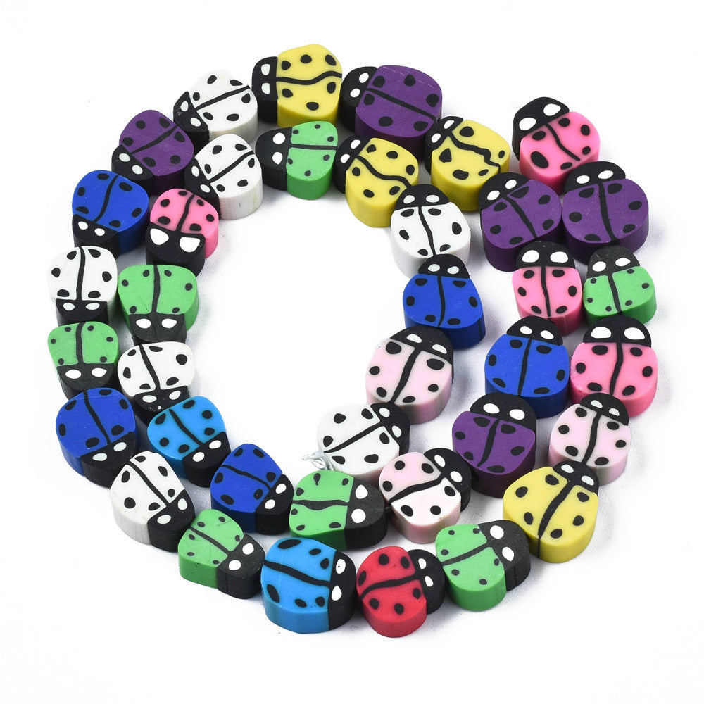 multicolor polymer clay ladybug bead strands in swirl design over white background. 