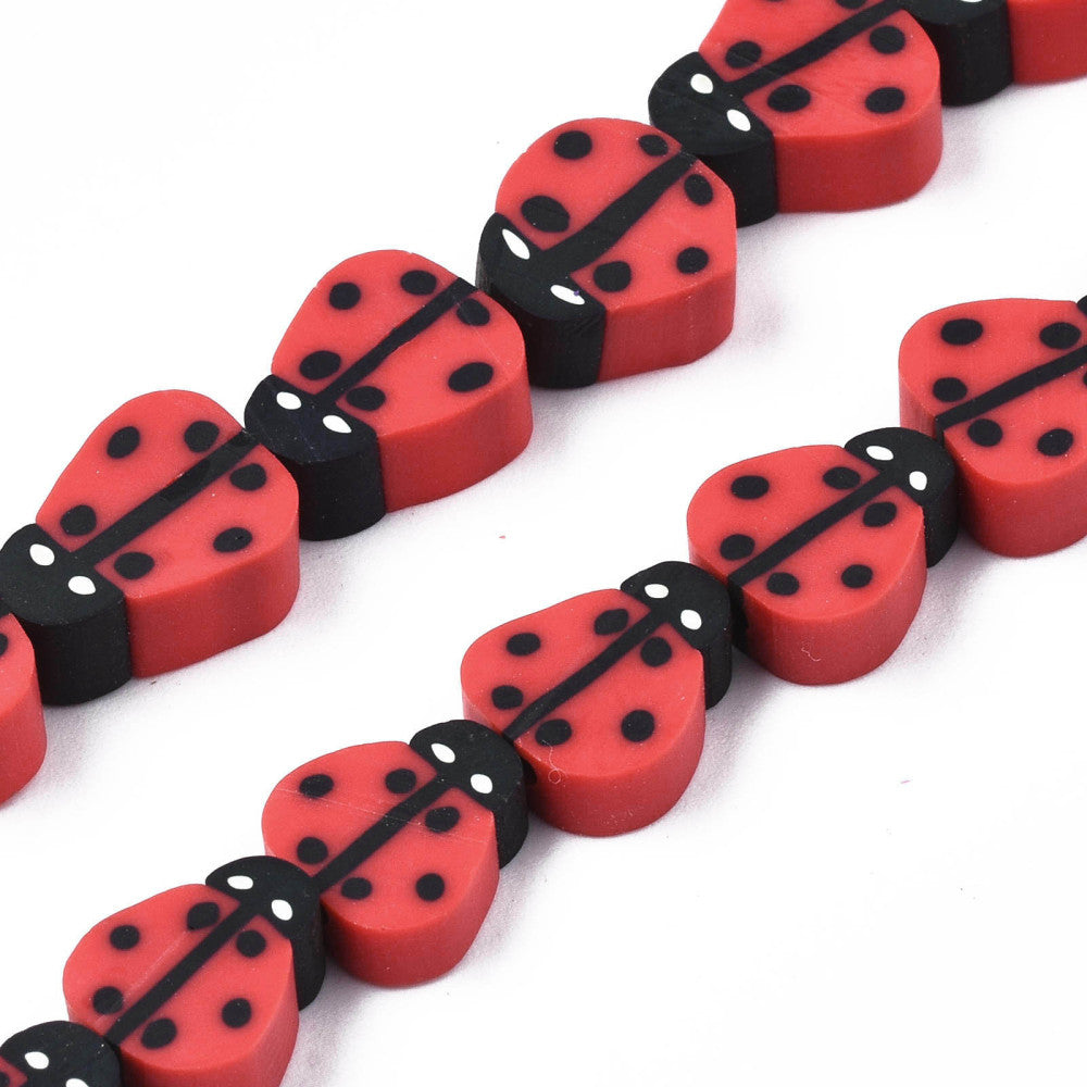 zoomed in sections red polymer clay ladybug bead strands over white background. 