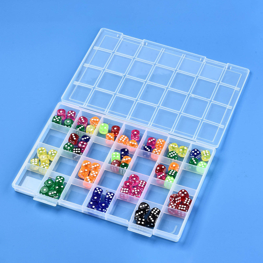 twenty-eight compartment clear plastic bead storage container displayed with multi-colored transparent dice in some compartments over light blue surface. 