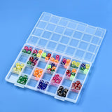 twenty-eight compartment clear plastic bead storage container displayed with multi-colored transparent dice in some compartments over light blue surface. 