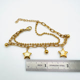 golden double layered, paperclip and ball chain bracelet with lobster claw clasp and extender above stainless steel imperial ruler on white background.  the paperclip chain dangles alternating ball and star charms. 