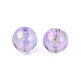 zoomed in photo of two iridescent purple round beads over white background. 