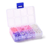 open eight compartment plastic bead box containing pink and purple and clear beads like letters or hearts or stars or rounds over white background. 