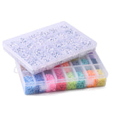 two closed plastic bead storage boxes with 26 compartments each, one filled with colorful disc beads and the other filled white with black letter beads stacked over white background.