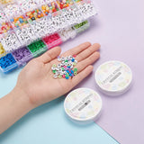 zoomed in view of two twenty-four compartment bead storage cases stacked and full of terracotta, acrylic, metal and alphabet beads and two crystal string spools along with a hand full of the beads over purple and blue surface. 