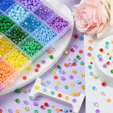 corner of rainbow bead box with an explosion of loose beads spread over white and light purple surfaces and a light pink rose in the corner. 